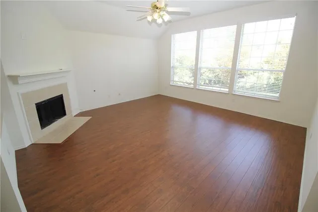 a view of a livingroom with a fireplace and a chandelier fan