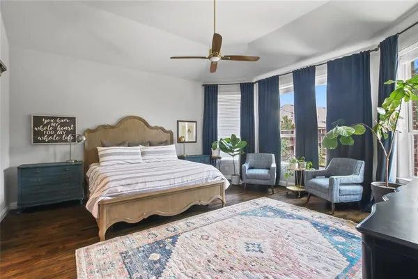 a bedroom with a bed a couch and a potted plant