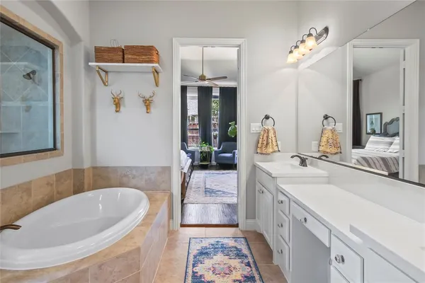 a bathroom with a tub sink and mirror