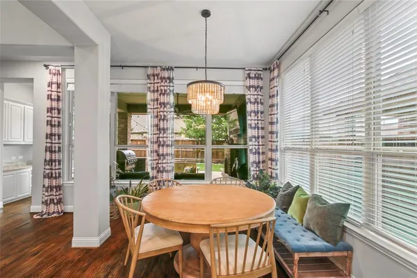 a dining room with furniture a chandelier and wooden floor