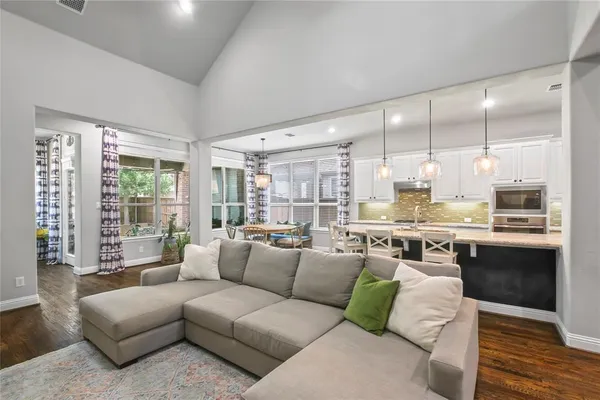 a living room with furniture wooden floor and a large window