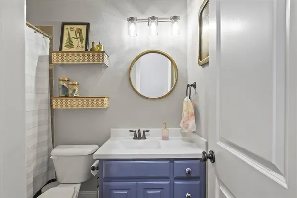 a bathroom with a toilet a sink and mirror