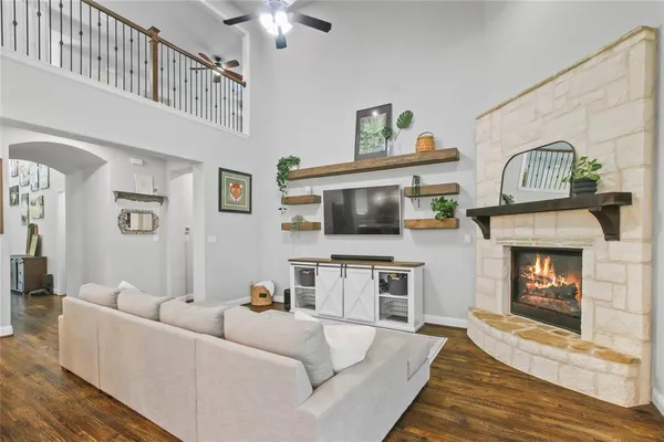 a living room with furniture a flat screen tv and a fireplace