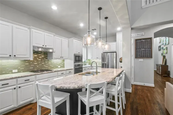 a kitchen with kitchen island granite countertop a table and chairs in it