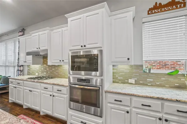 a kitchen with granite countertop white cabinets stainless steel appliances and a sink