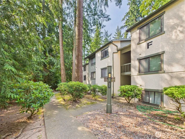 a view of a brick house with a yard and plants