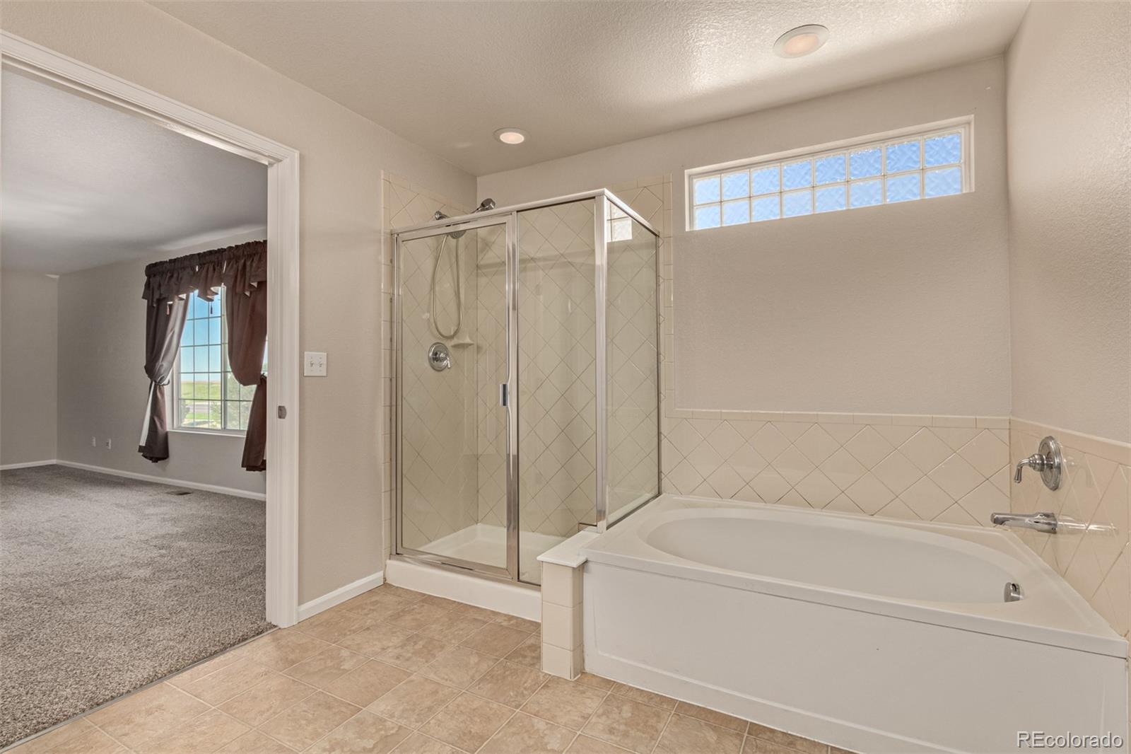 5344 North Perth Street Denver, CO 80249 - Photo 28 of 39 a bathroom with a bathtub and a shower