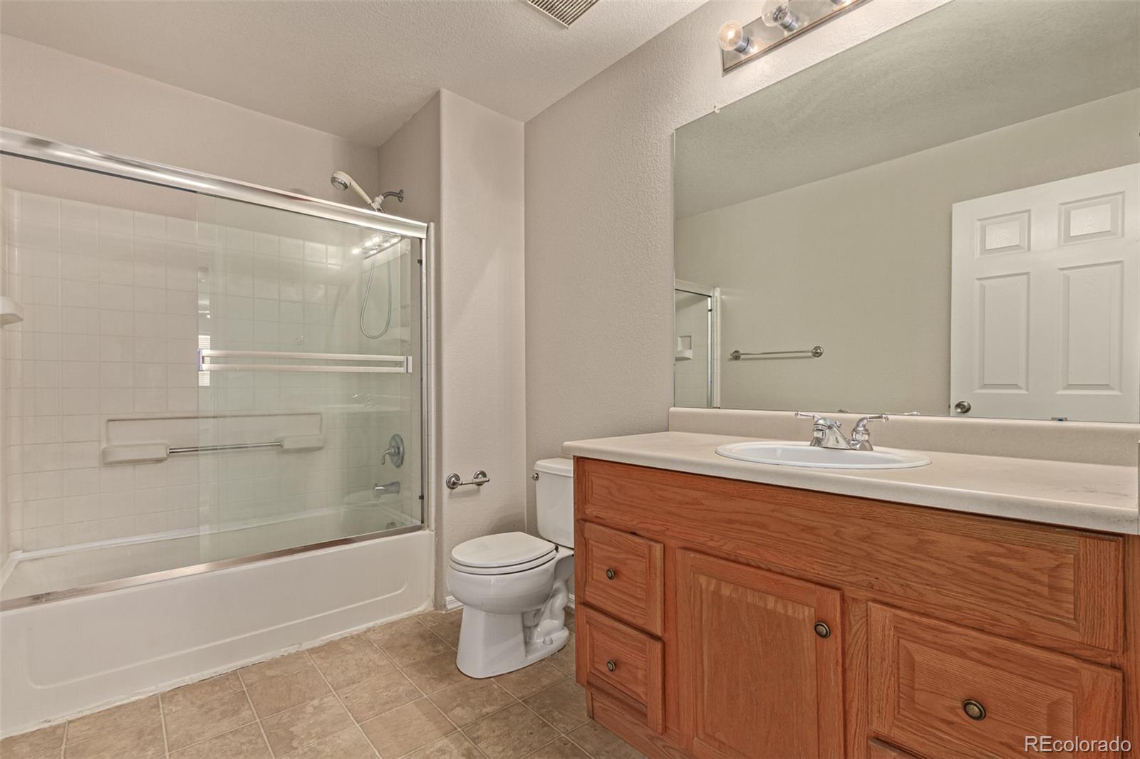 5344 North Perth Street Denver, CO 80249 - Photo 35 of 39 a bathroom with a granite countertop sink toilet and shower