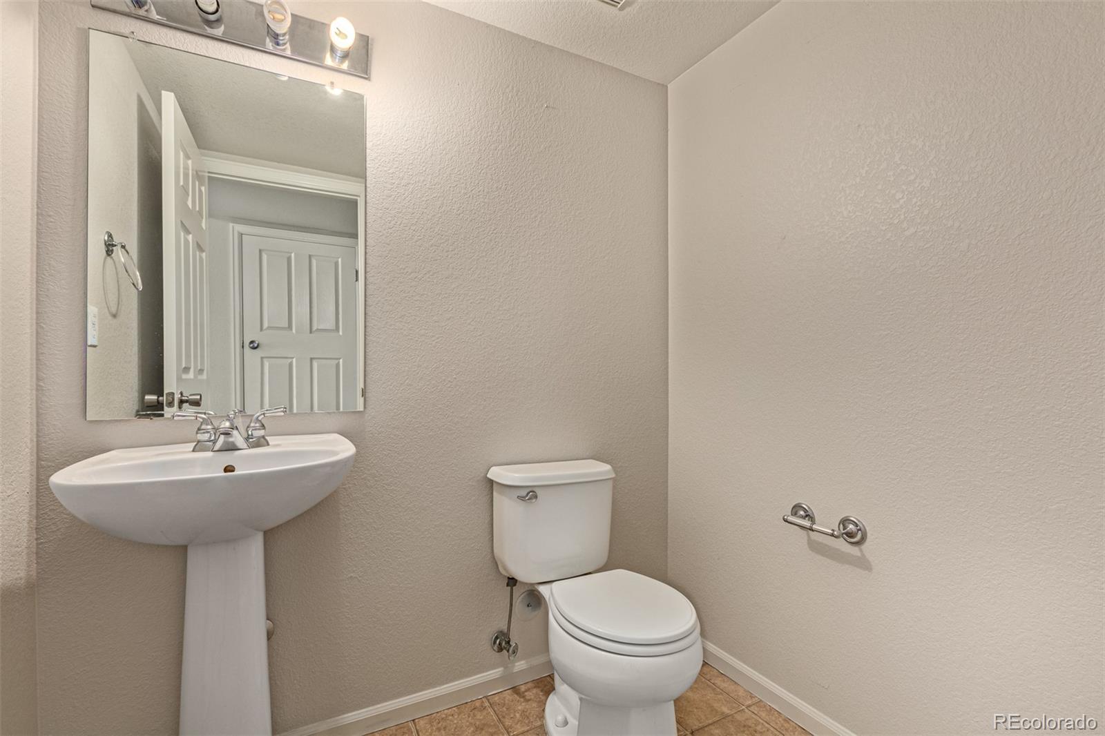 5344 North Perth Street Denver, CO 80249 - Photo 37 of 39 a bathroom with a sink mirror and toilet