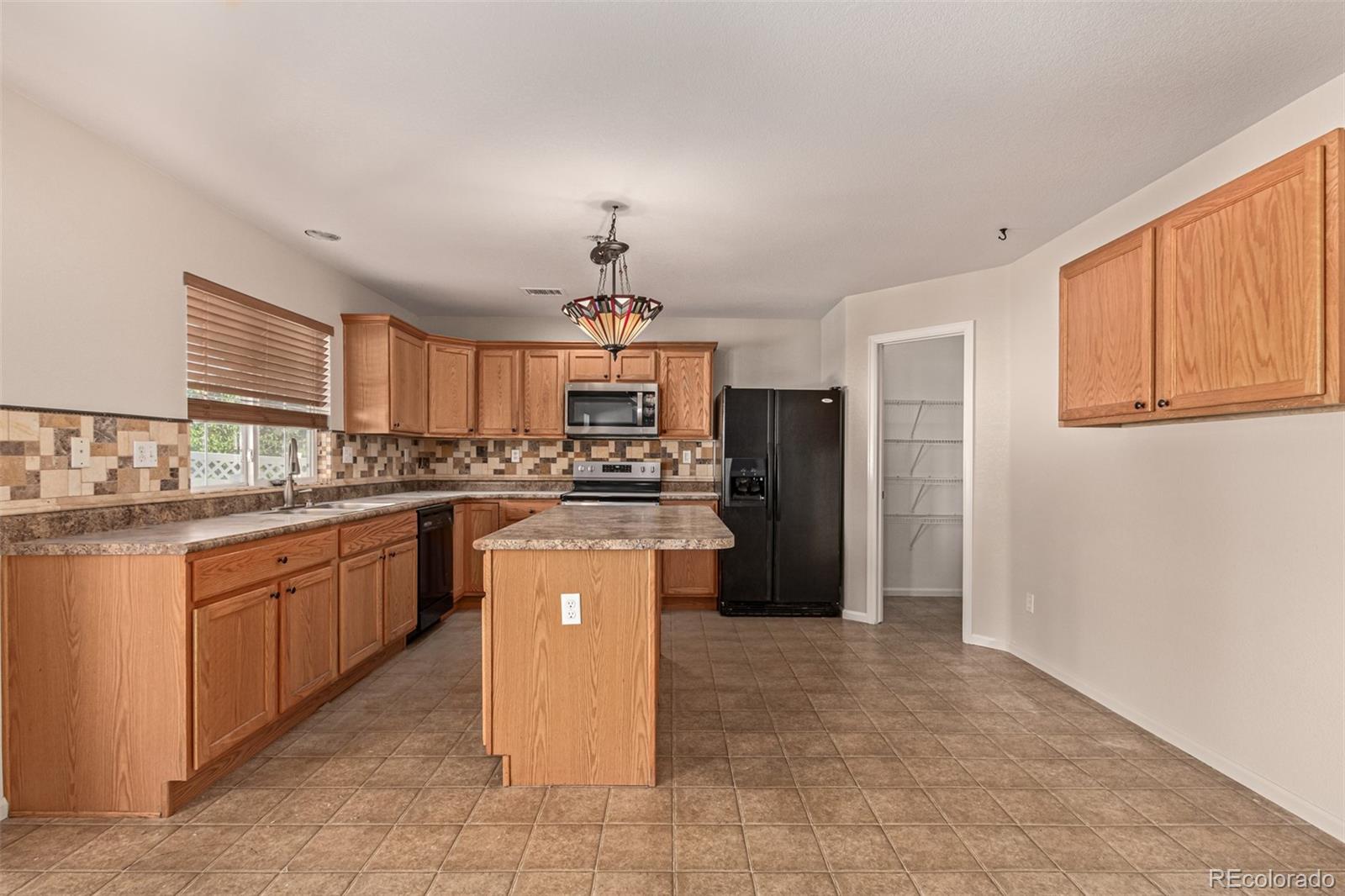 5344 North Perth Street Denver, CO 80249 - Photo 7 of 39 a kitchen with stainless steel appliances granite countertop a refrigerator a stove a sink a microwave and island