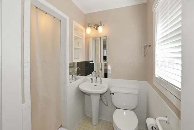 a bathroom with a toilet a sink and mirror