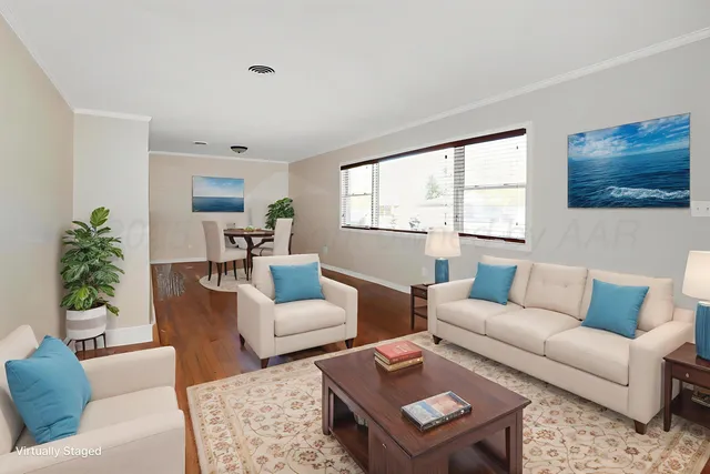 a living room with furniture a flat screen tv and a window