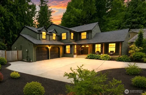 a front view of a house with yard and parking
