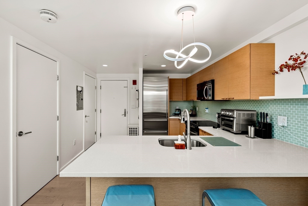 1 Earhart Street, Unit 705 Cambridge, MA 02141 - Photo 11 of 38 a kitchen with stainless steel appliances granite countertop a sink a stove and a refrigerator