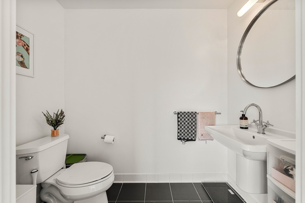1 Earhart Street, Unit 705 Cambridge, MA 02141 - Photo 30 of 38 a bathroom with a sink toilet and a mirror