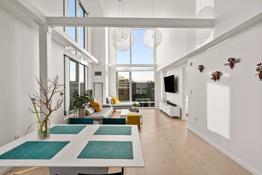 1 Earhart Street, Unit 705 Cambridge, MA 02141 - Photo 31 of 38 a living room with furniture large windows and a flat screen tv
