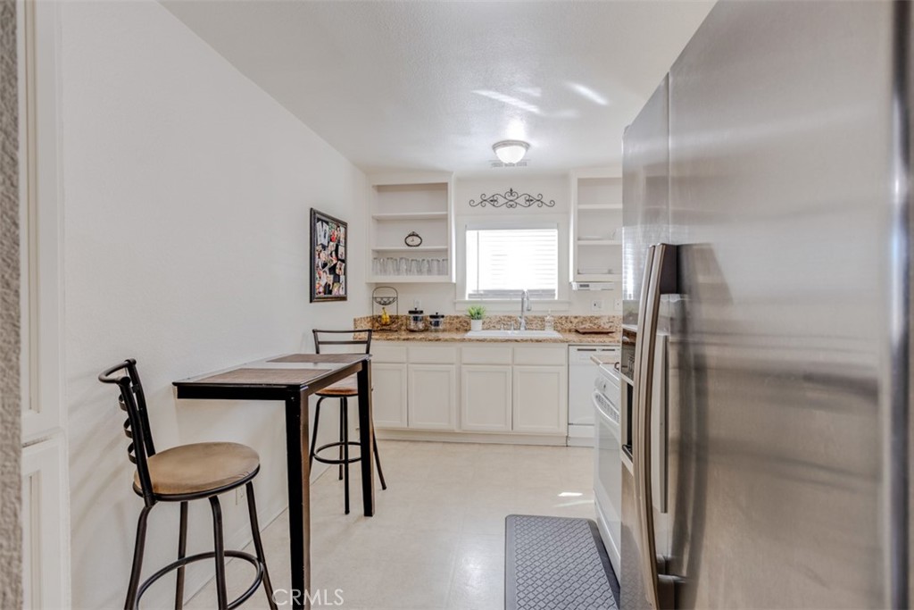 15461 Hesperia Road Victorville, CA 92395 - Photo 11 of 28 a kitchen with a refrigerator and table chair