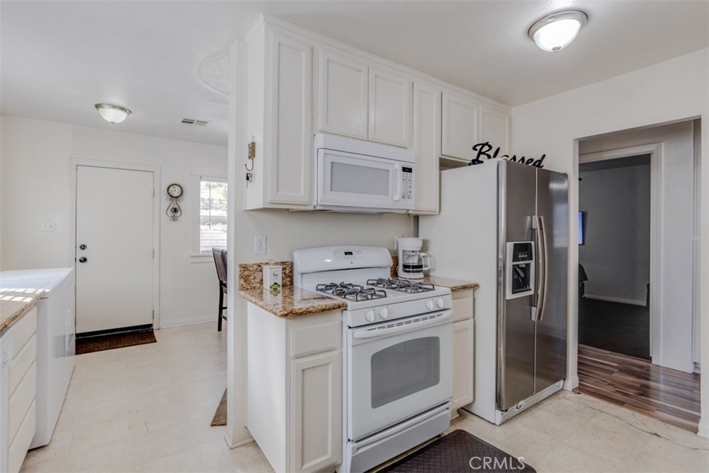 15461 Hesperia Road Victorville, CA 92395 - Photo 13 of 28 a kitchen with stainless steel appliances white cabinets and a refrigerator