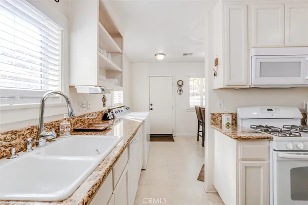 a kitchen with stainless steel appliances a sink stove and cabinets