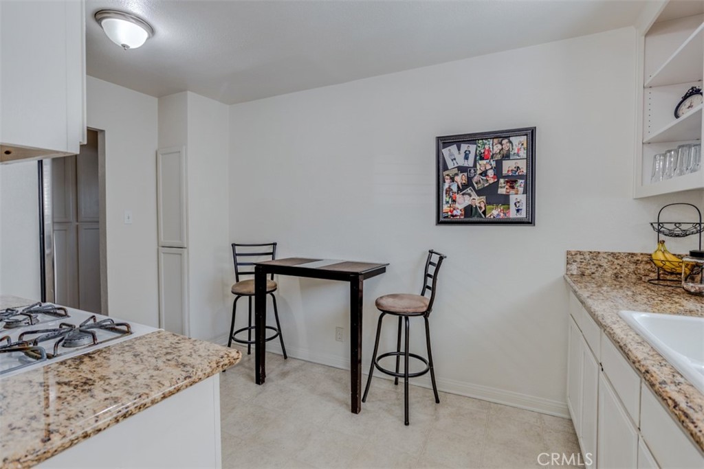 15461 Hesperia Road Victorville, CA 92395 - Photo 16 of 28 a bathroom with a granite countertop sink a desk and chair