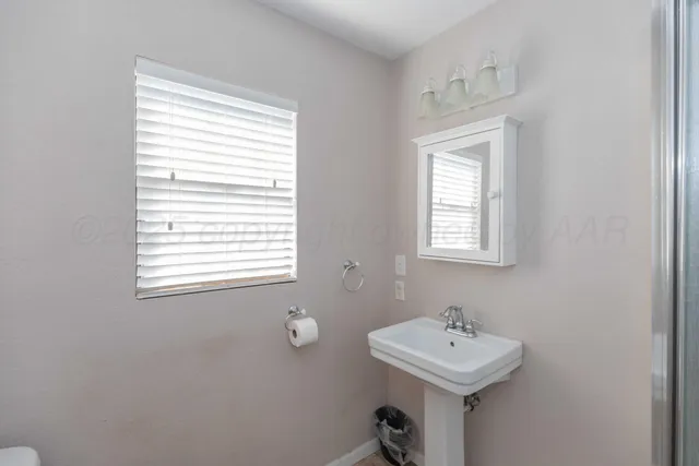a bathroom with a sink a mirror and a window