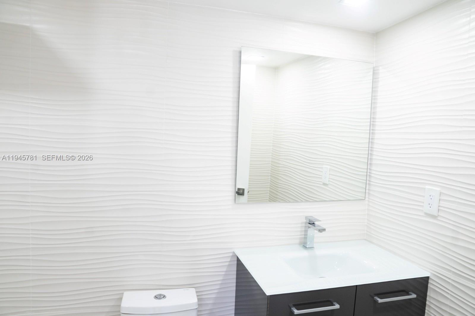 220 Southwest 9th Avenue, Unit 306 Hallandale Beach, FL 33009 - Photo 17 of 30 a bathroom with a sink and a mirror