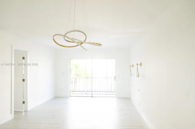 a view of a room with wooden floor and white walls