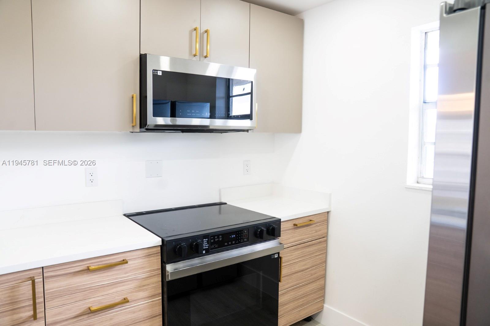 220 Southwest 9th Avenue, Unit 306 Hallandale Beach, FL 33009 - Photo 23 of 30 a kitchen with a stove and a microwave