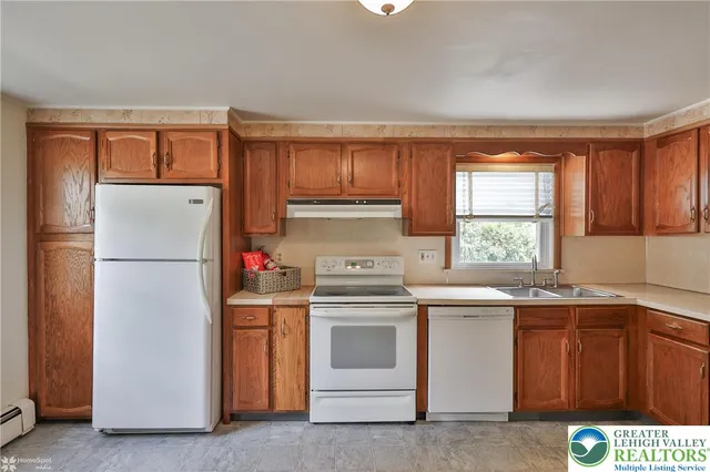a kitchen with a white stove top oven and refrigerator