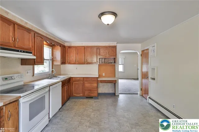 a kitchen with granite countertop a sink stove and refrigerator
