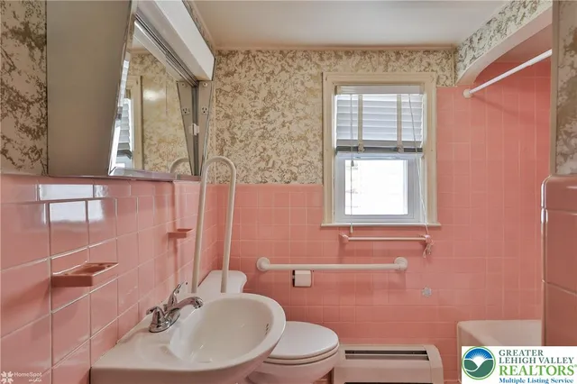 a bathroom with a sink a toilet and mirror