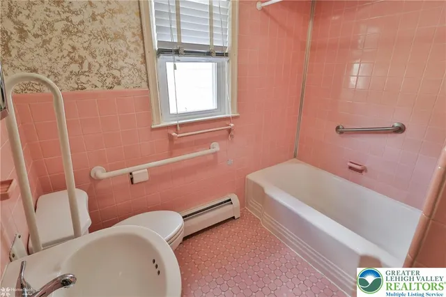 a bathroom with a sink and bathtub with toilet