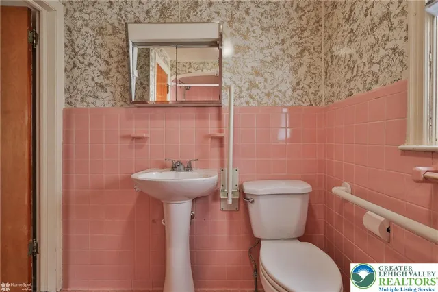 a bathroom with a toilet a sink and mirror