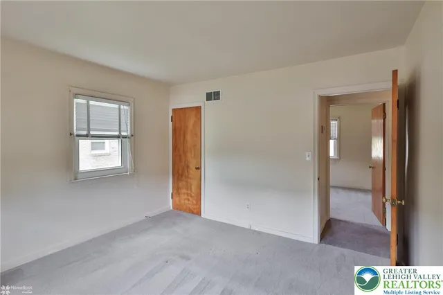 an empty room with windows and closet