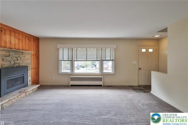 wooden floor fireplace and windows in an empty room
