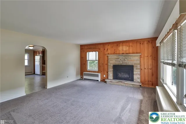 a view of an empty room with a fireplace and a window
