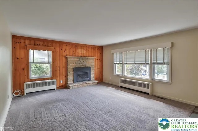 an empty room with a fireplace and windows