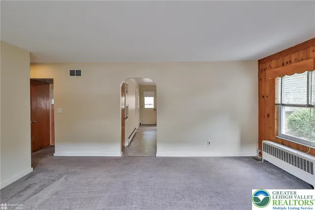 an empty room with windows and closet