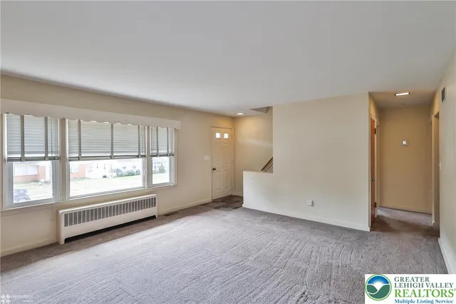 an empty room with windows and closet