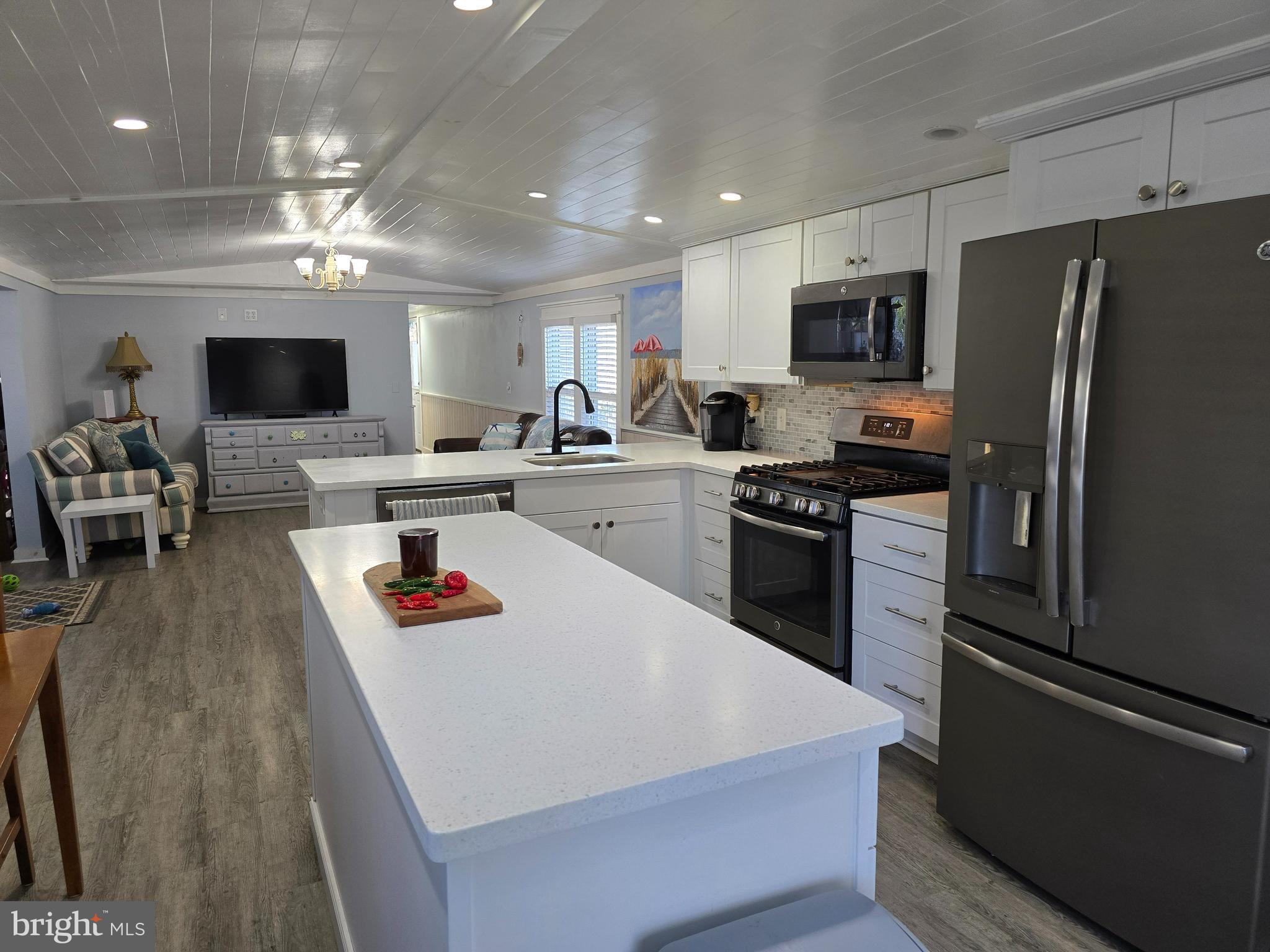 33500 Clover Street Lewes, DE 19958 - Photo 12 of 39 a kitchen with a refrigerator a stove top oven a sink dishwasher and white cabinets with wooden floor