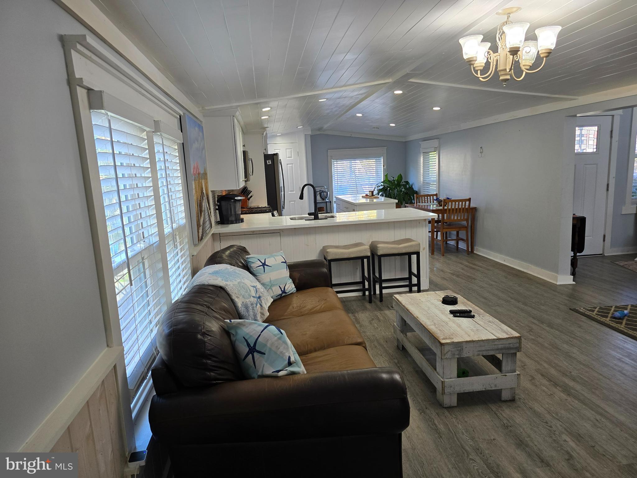 33500 Clover Street Lewes, DE 19958 - Photo 13 of 39 a living room with furniture a chandelier and a flat screen tv