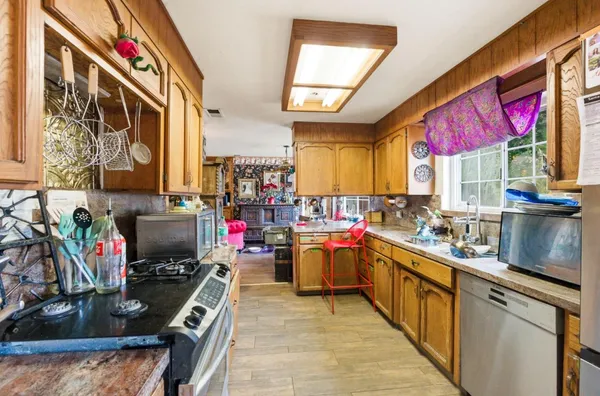 a kitchen with lots of counter top space appliances and windows