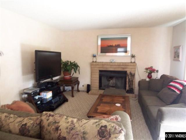 5370 Mountcrest Lane Reno, NV 89523 - Photo 7 of 10 a living room with furniture a flat screen tv and a fireplace
