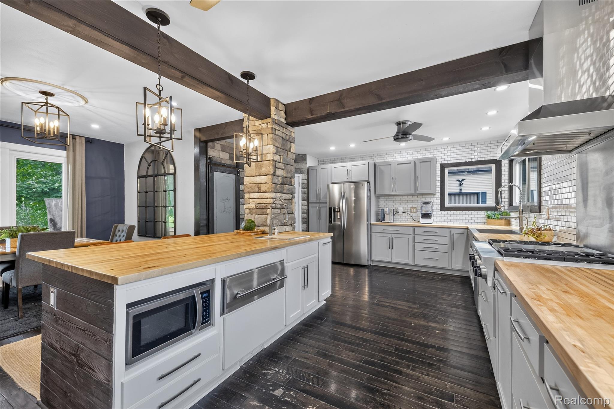 4860 Blue Bush Road Monroe, MI 48162 - Photo 10 of 59 Kitchen featuring dark wood-finish flooring, light grey cabinetry, butcher block countertops, stainless steel appliances, and a mosaic tile backsplash