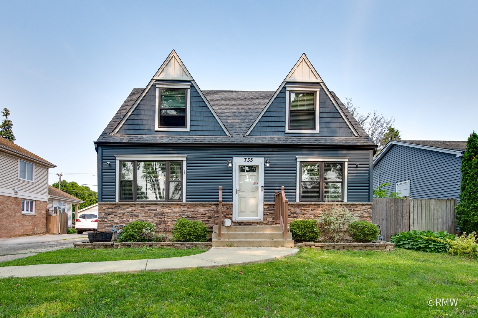 a front view of a house with a yard and potted plants