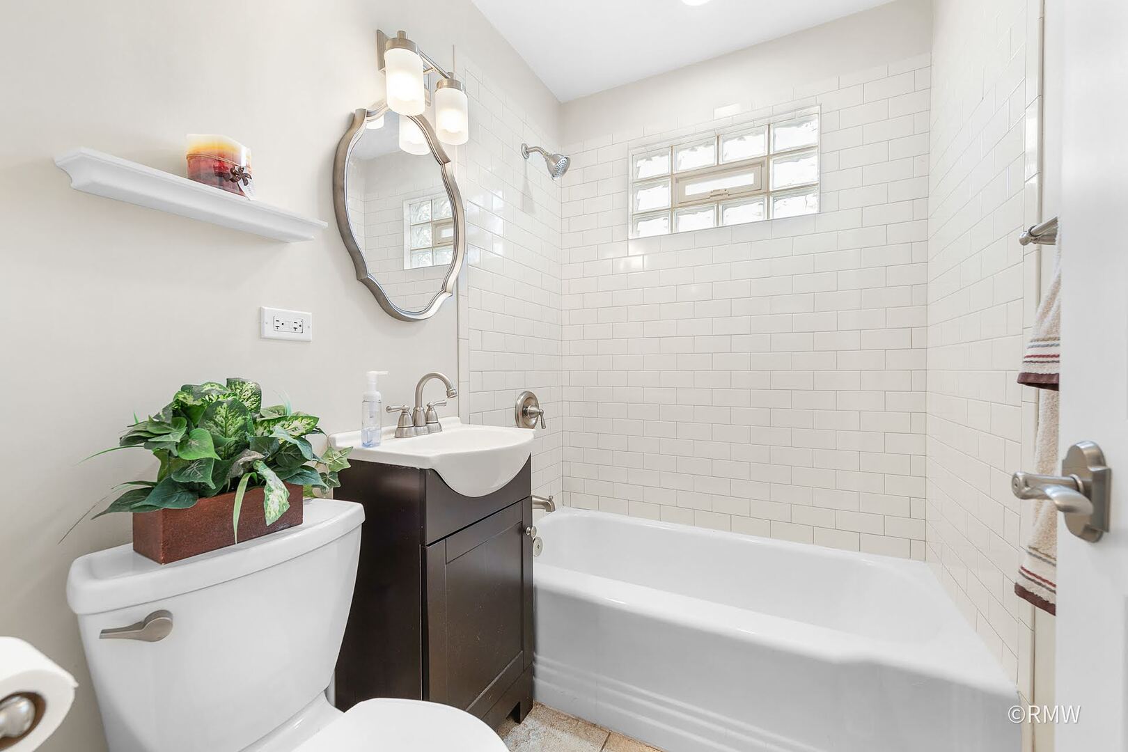 735 Spring Road Elmhurst, IL 60126 - Photo 8 of 34 a bathroom with a sink a mirror a bathtub and a shower