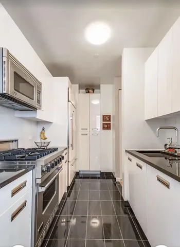 a kitchen with granite countertop a stove and a refrigerator