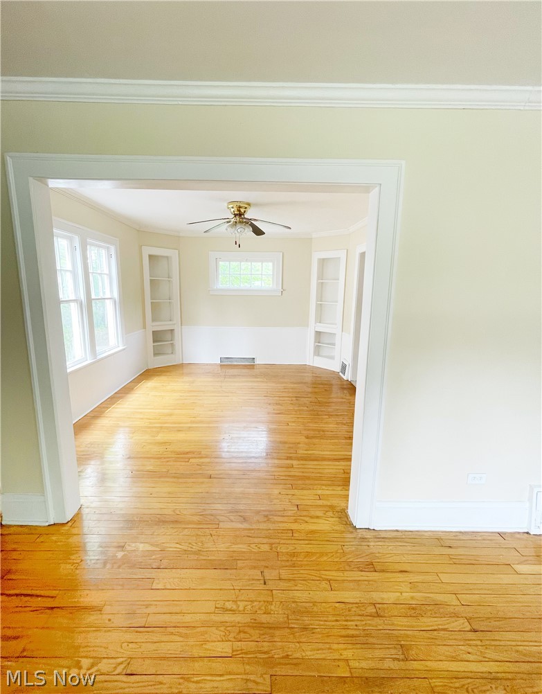 3345 Sylvanhurst Road Cleveland Heights, OH 44112 - Photo 5 of 16 Empty room with built in features, plenty of natural light, light hardwood / wood-style floors, and ceiling fan