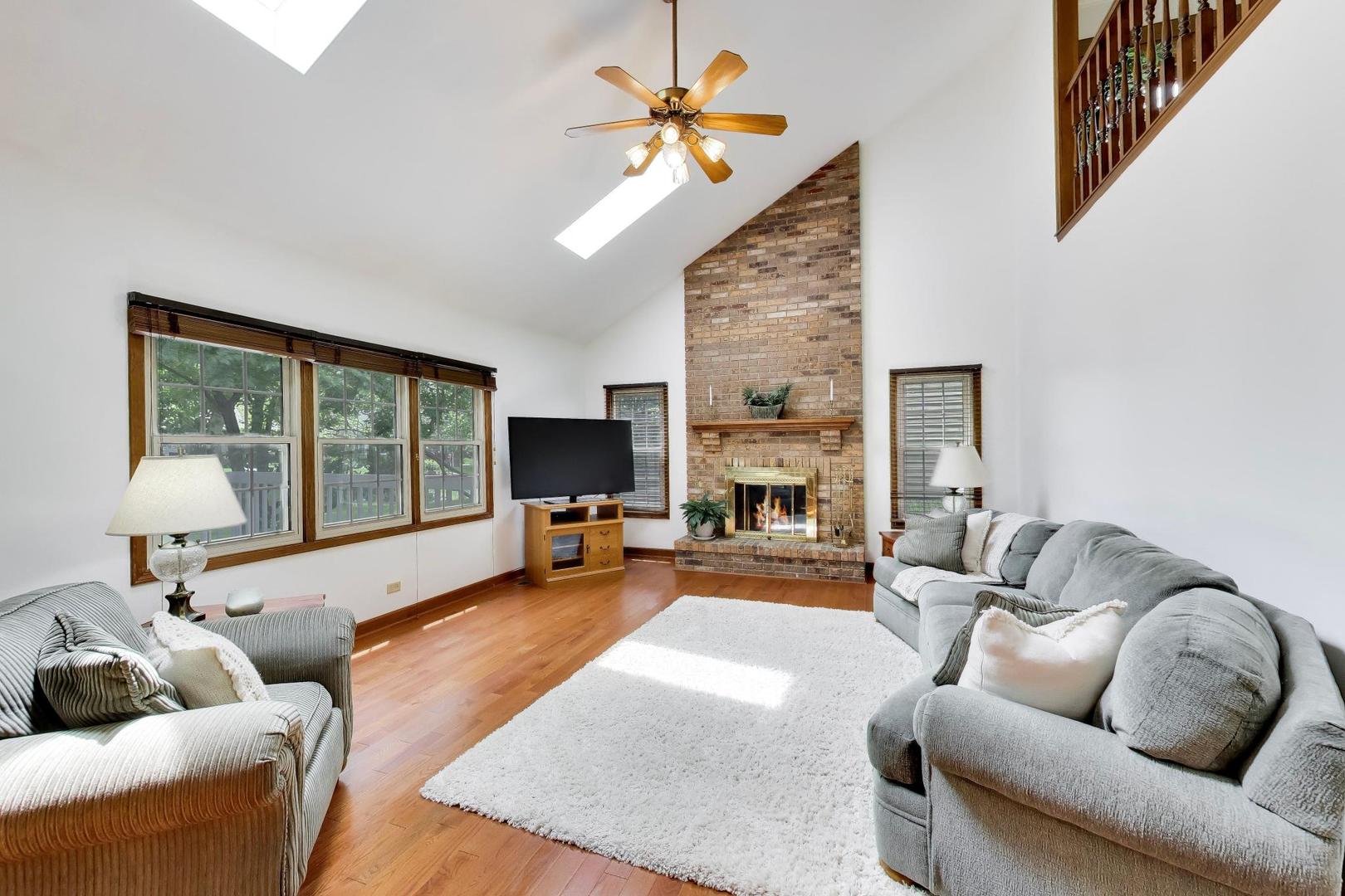1528 Sequoia Road Naperville, IL 60540 - Photo 12 of 34 a living room with furniture a fireplace and a flat screen tv