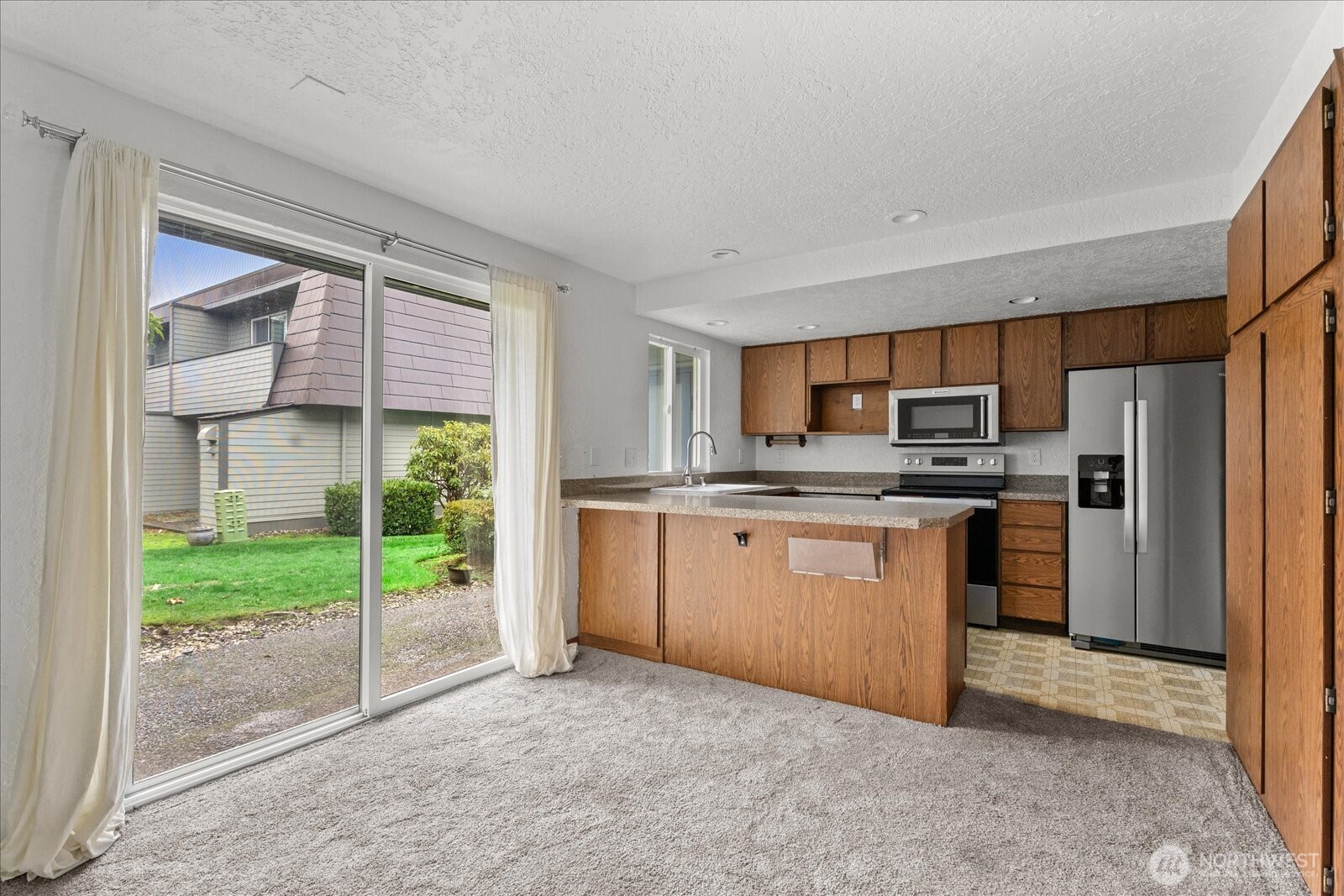12600 4th Avenue West, Unit 7H Everett, WA 98204 - Photo 5 of 30 a kitchen with stainless steel appliances a refrigerator sink and cabinets